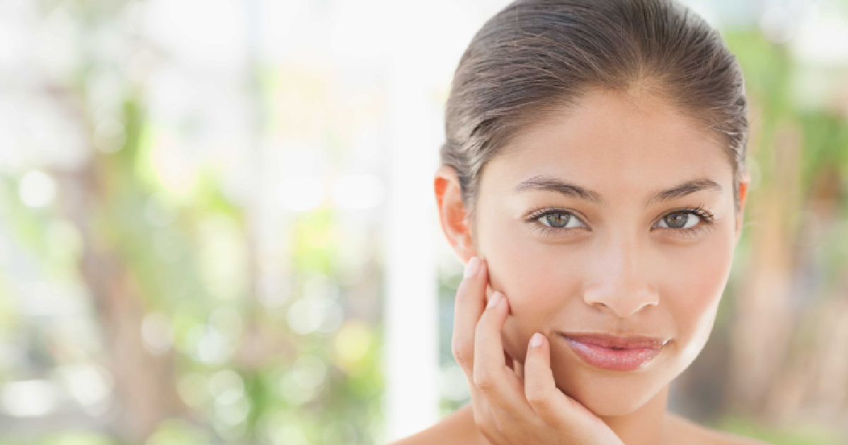 woman with clear, glowing skin gently touching her face, showcasing a healthy and radiant complexion after Micro Glow Infusion in Brentwood, TN.